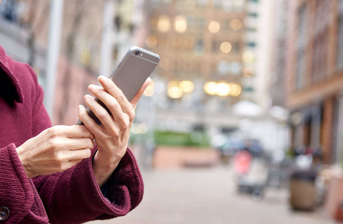 Most Helpful Apps For New Yorkers: woman holding phone outside