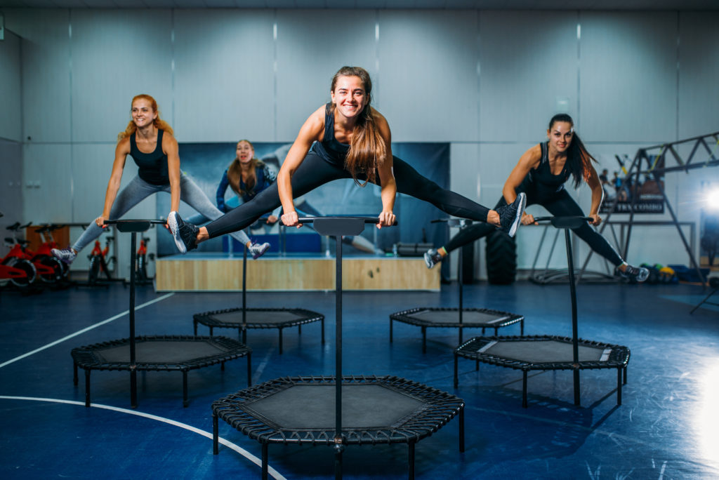 8 Fun and Unique Exercise Classes in NYC -Women group on sport trampoline, fitness workout